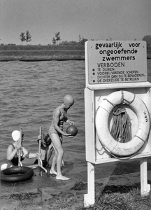 361175 Afbeelding van enkele jeugdige zwemmers in het Amsterdam-Rijnkanaal te Utrecht, met rechts een waarschuwingsbord ...